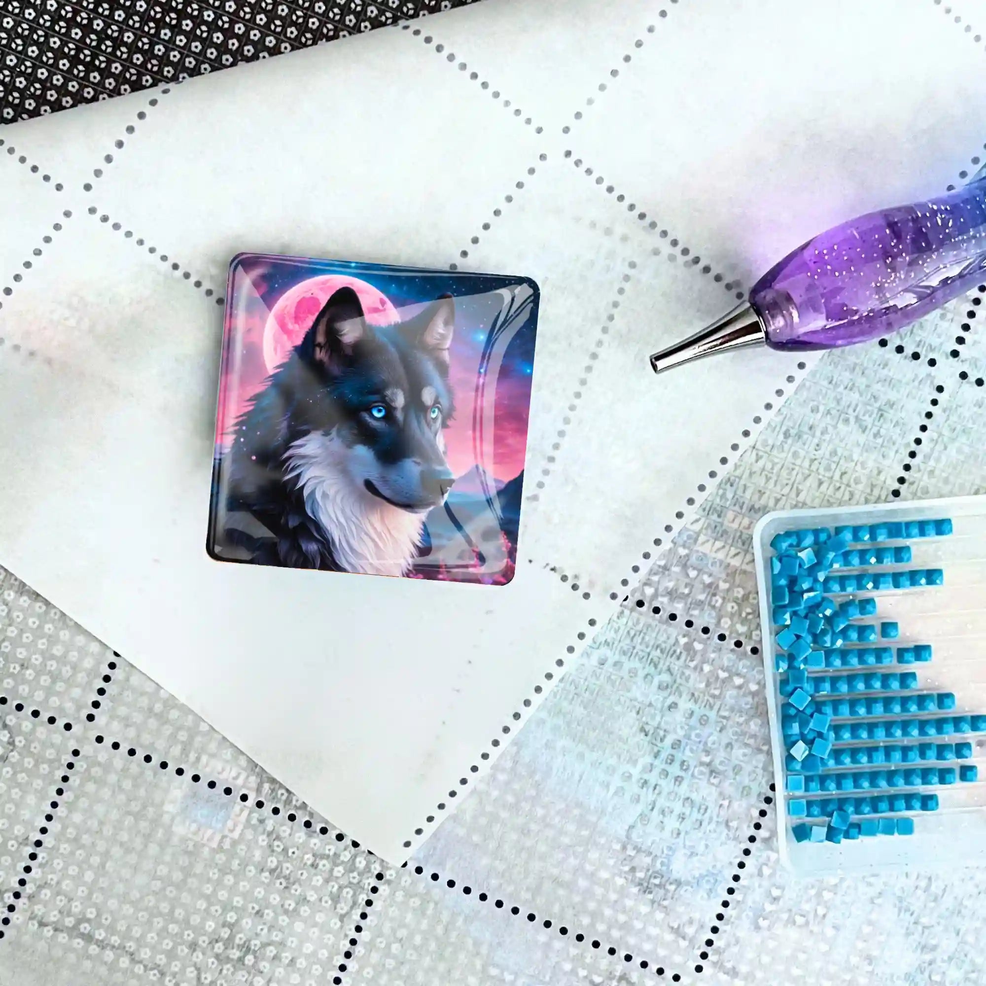 Quadratischer Diamond Painting Cover Minder mit Wolf-Motiv vor Erdbeermond auf einer Leinwand mit Zubehör