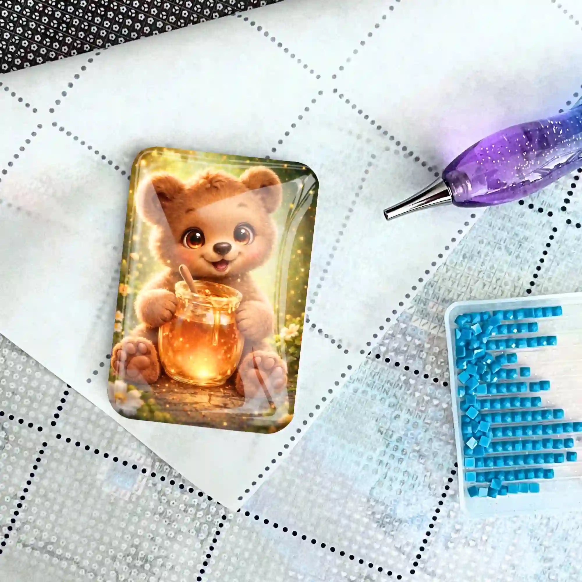 Süßer Bären-Coverminder auf einer Diamond Painting Leinwand mit Glitzersteinen und Applikationsstift als DIY-Zubehör