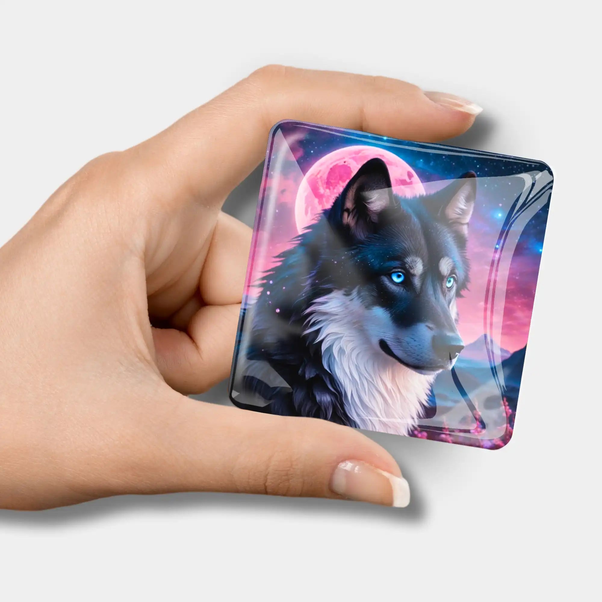 Quadratischer Diamond Painting Cover Minder Unter dem Erdbeermond mit Wolf Motiv in einer Hand gehalten