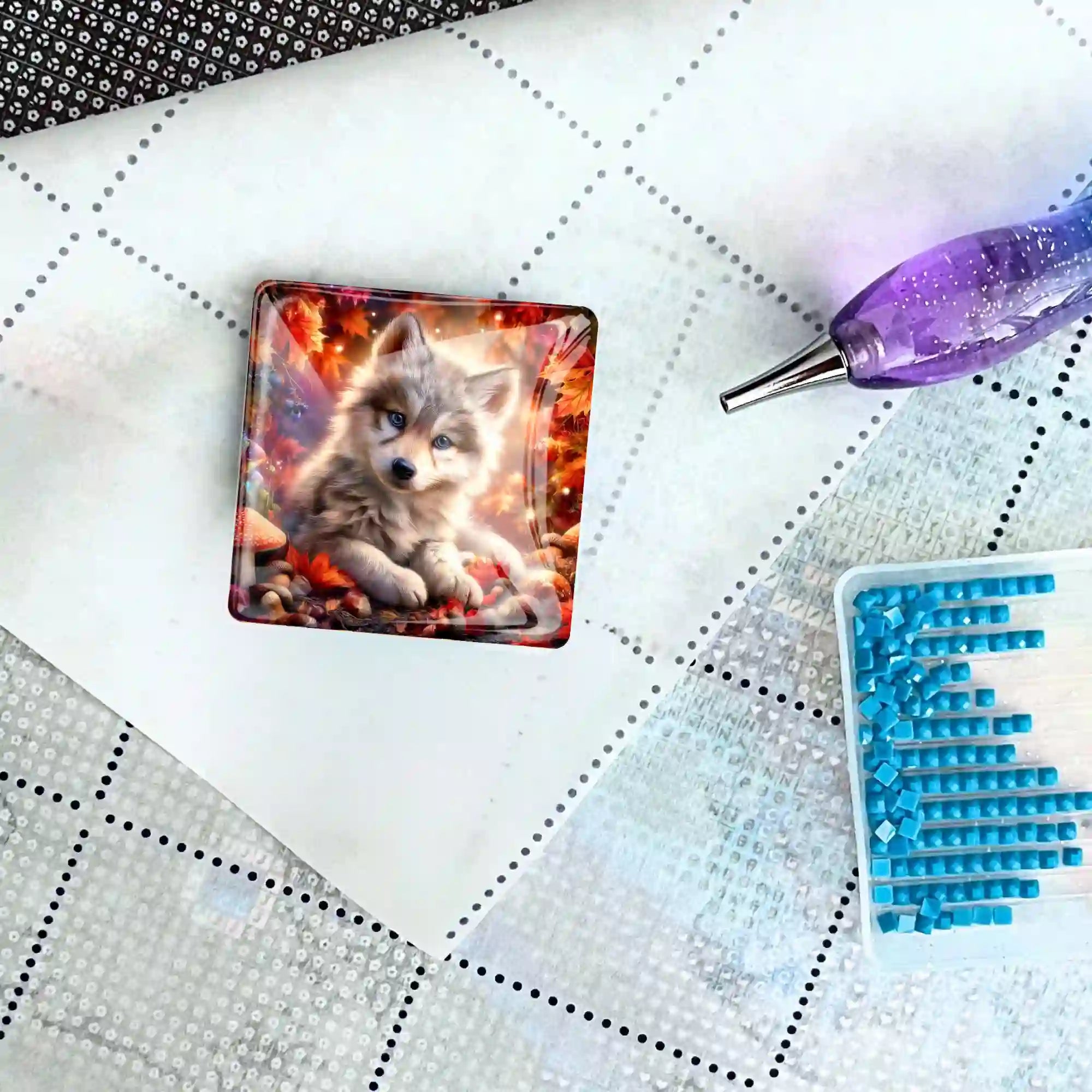 Quadratischer Diamond Painting Cover Minder Akiro mit Wolf-Motiv auf einer Leinwand mit Stift und blauen Diamanten