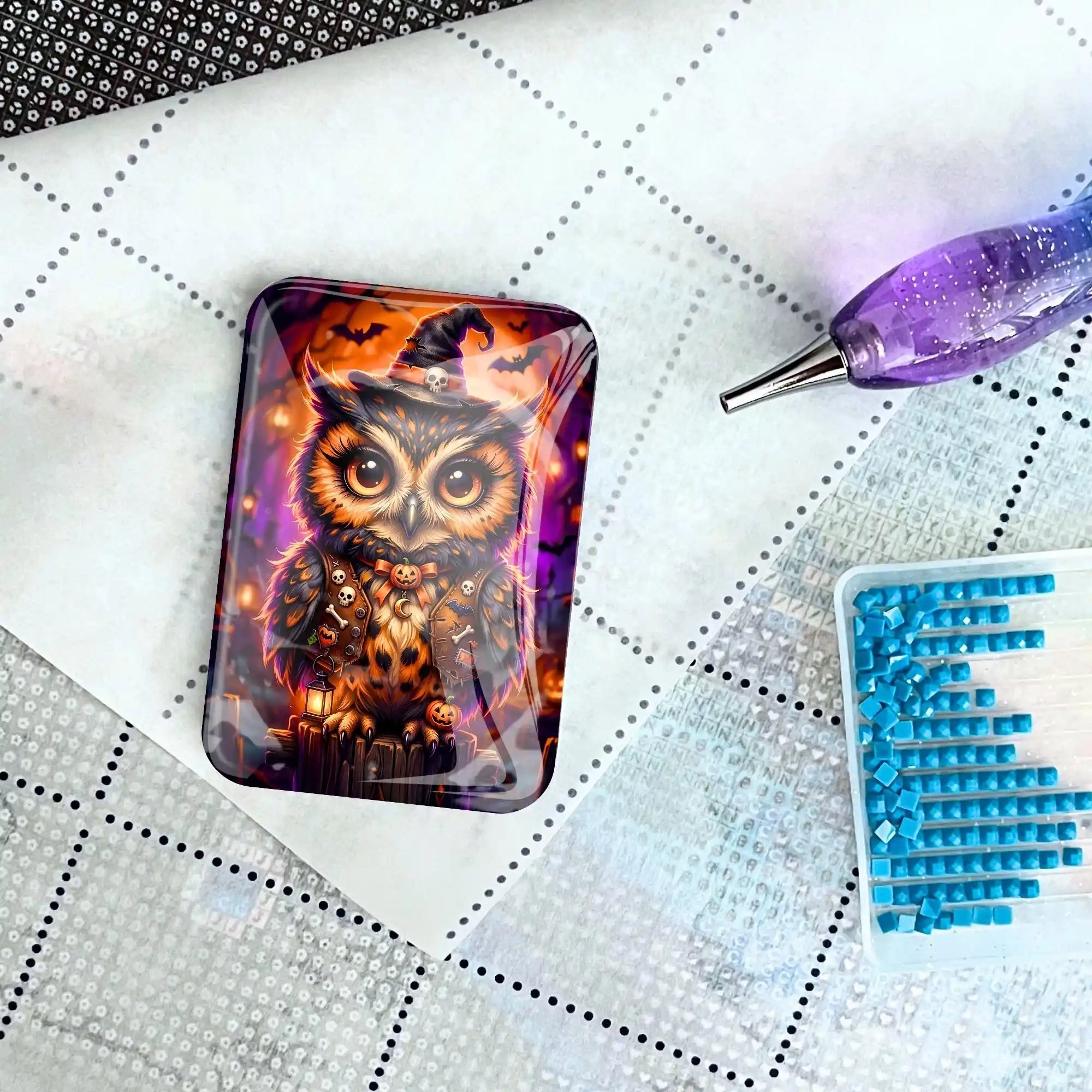 Eulen-Cover Minder mit Hexenhut für Diamond Painting, platziert auf einer Leinwand mit Stift und Glitzersteinen