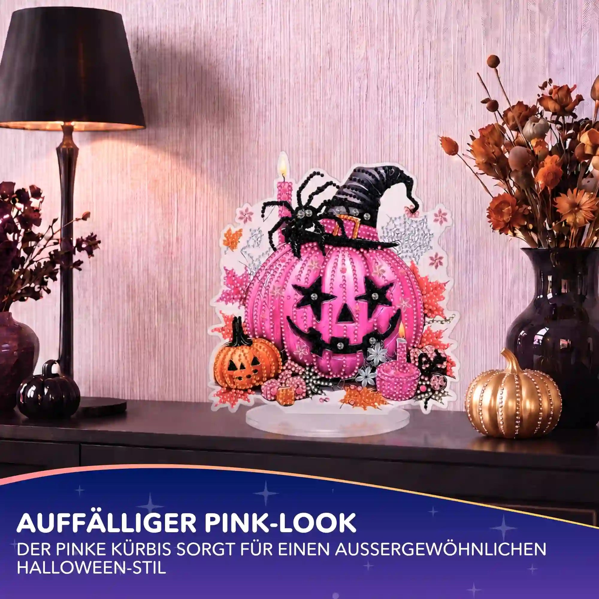 Mit funkelnden Steinen verziertes Diamond Painting Set als pinker Halloween-Kürbis-Aufsteller auf einem Sideboard.